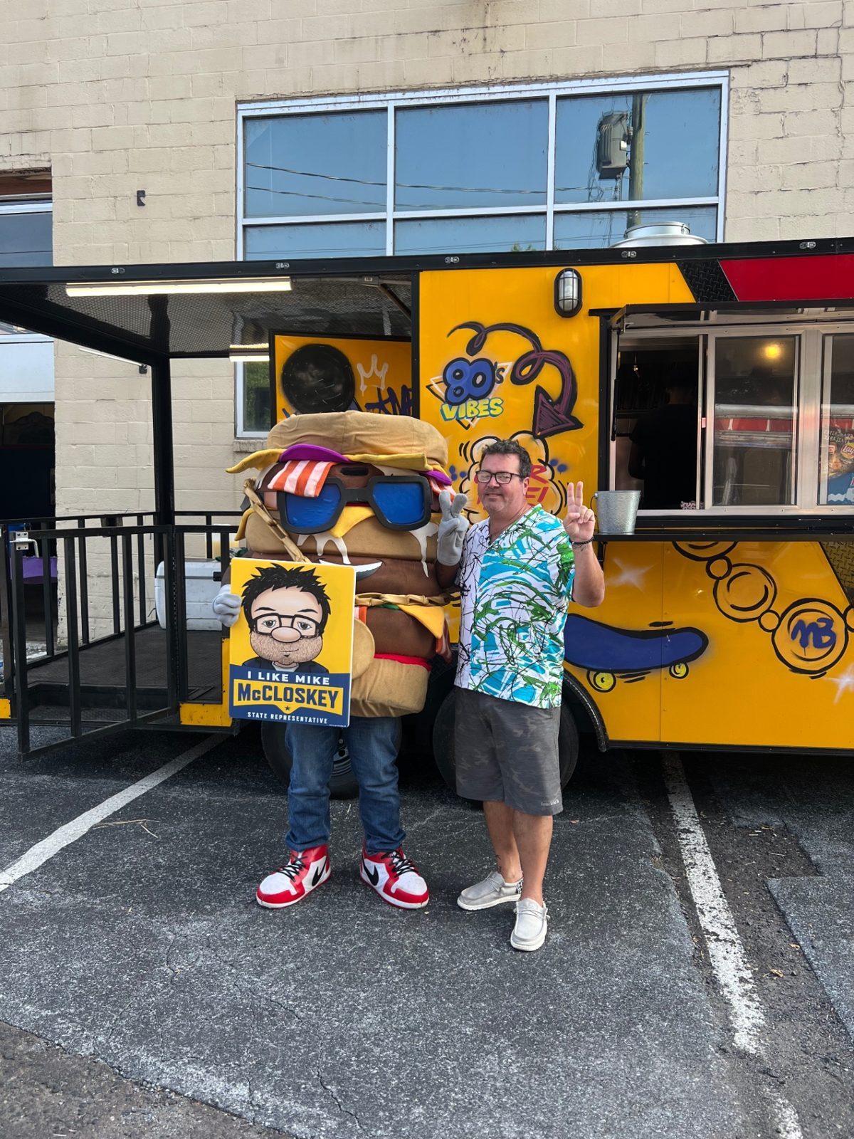 Mallie's Burgers mascot posing with a guest in front of the food truck