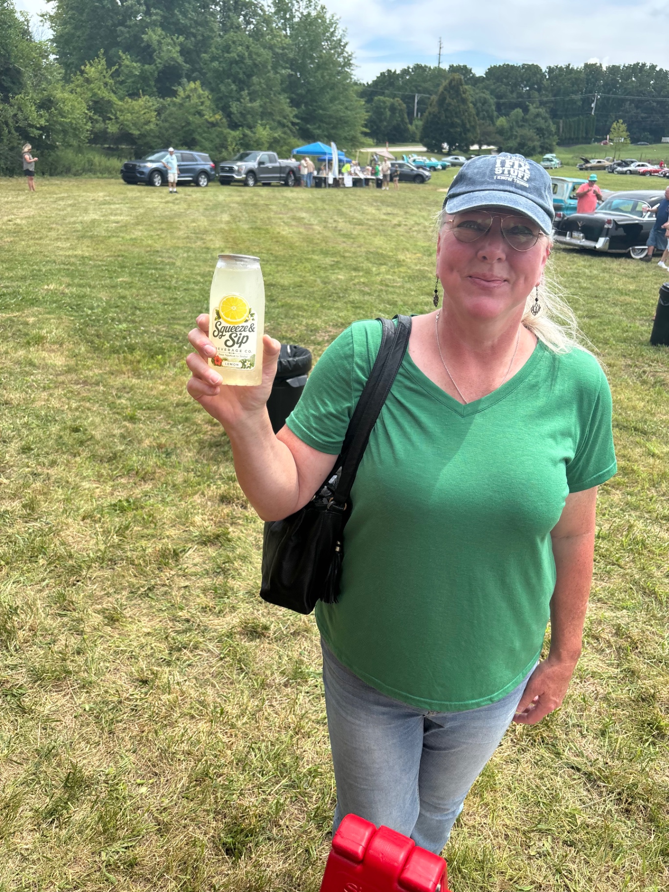 Guest holding a classic lemon Squeeze & Sip lemonade at a Pennsylvania car show served by Mallie's Burgers