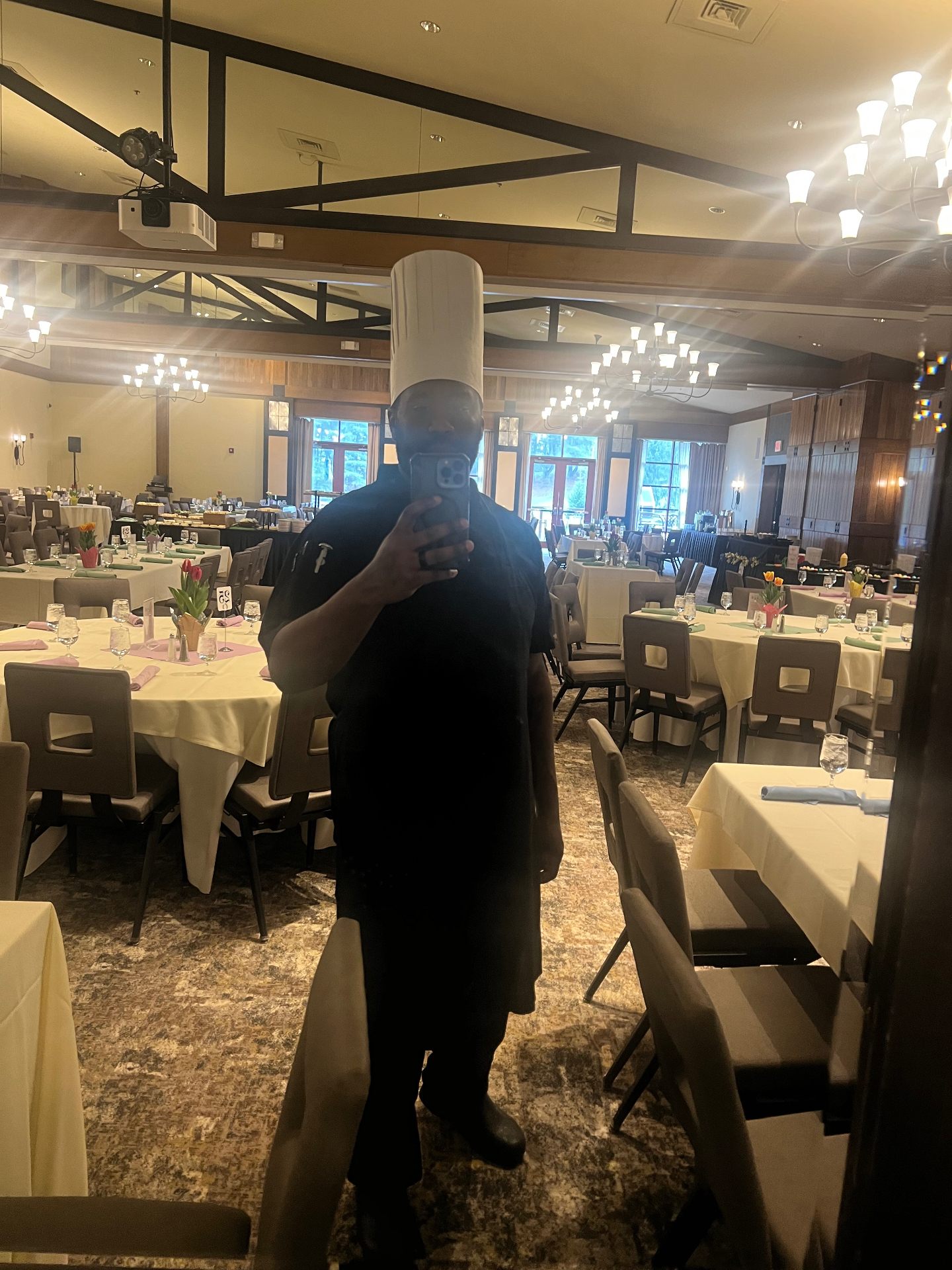 Chef Jamal in full black chef uniform with a white toque in a banquet hall
