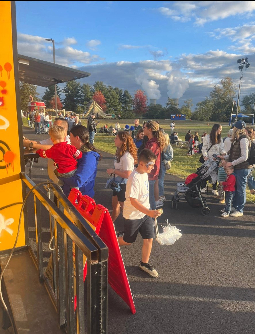 Families ordering at the Mallie's Burgers truck during an outdoor school field event