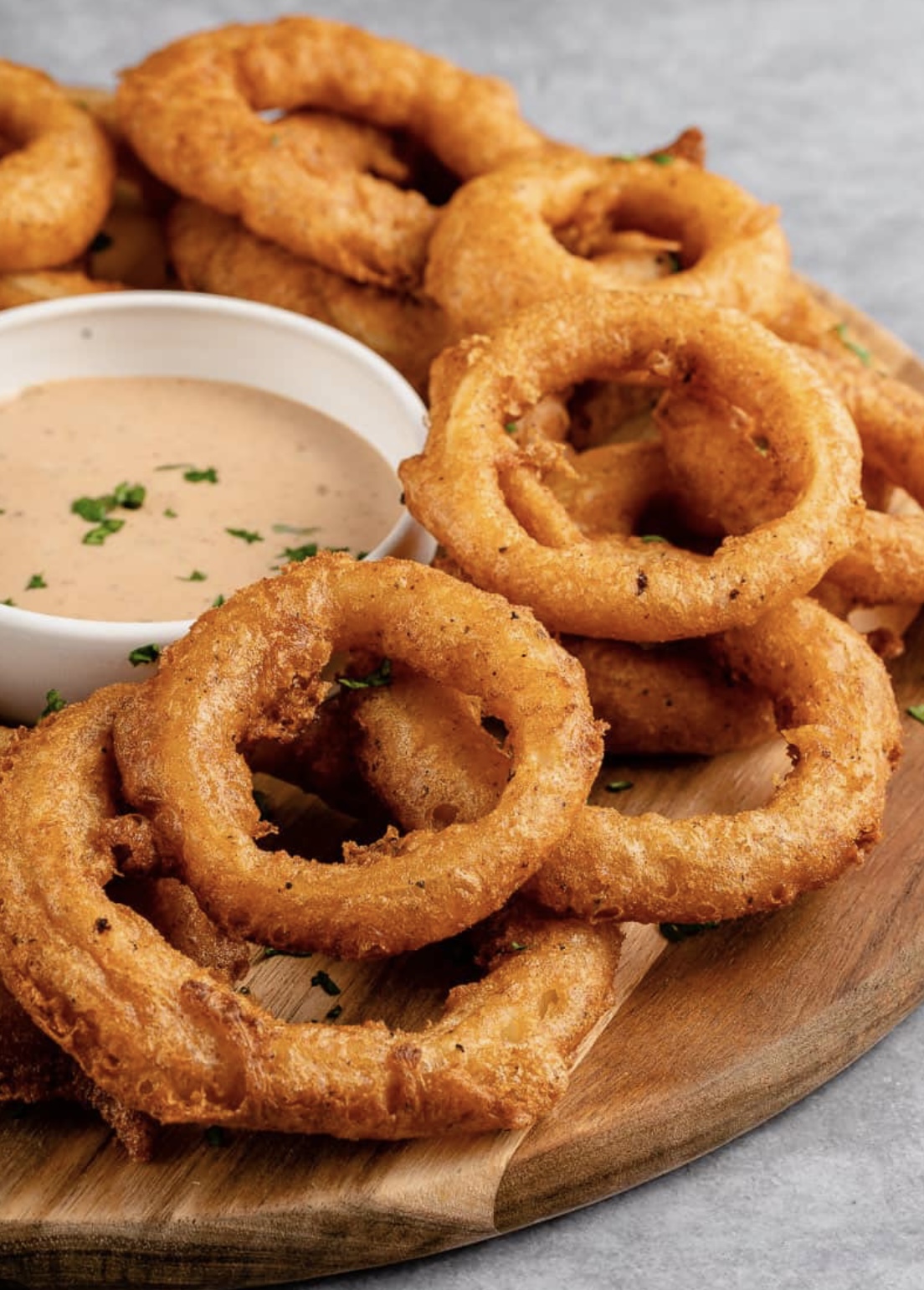 Platter of golden, crispy beer-battered onion rings cooked to order