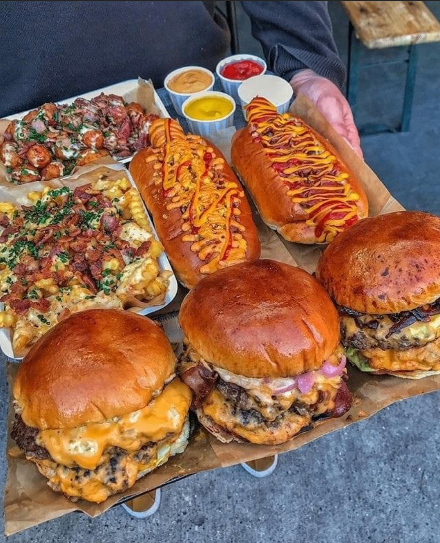 Tray of Mallie's catering favorites including cheeseburgers, loaded fries, wings and topped hot dogs with dipping sauces