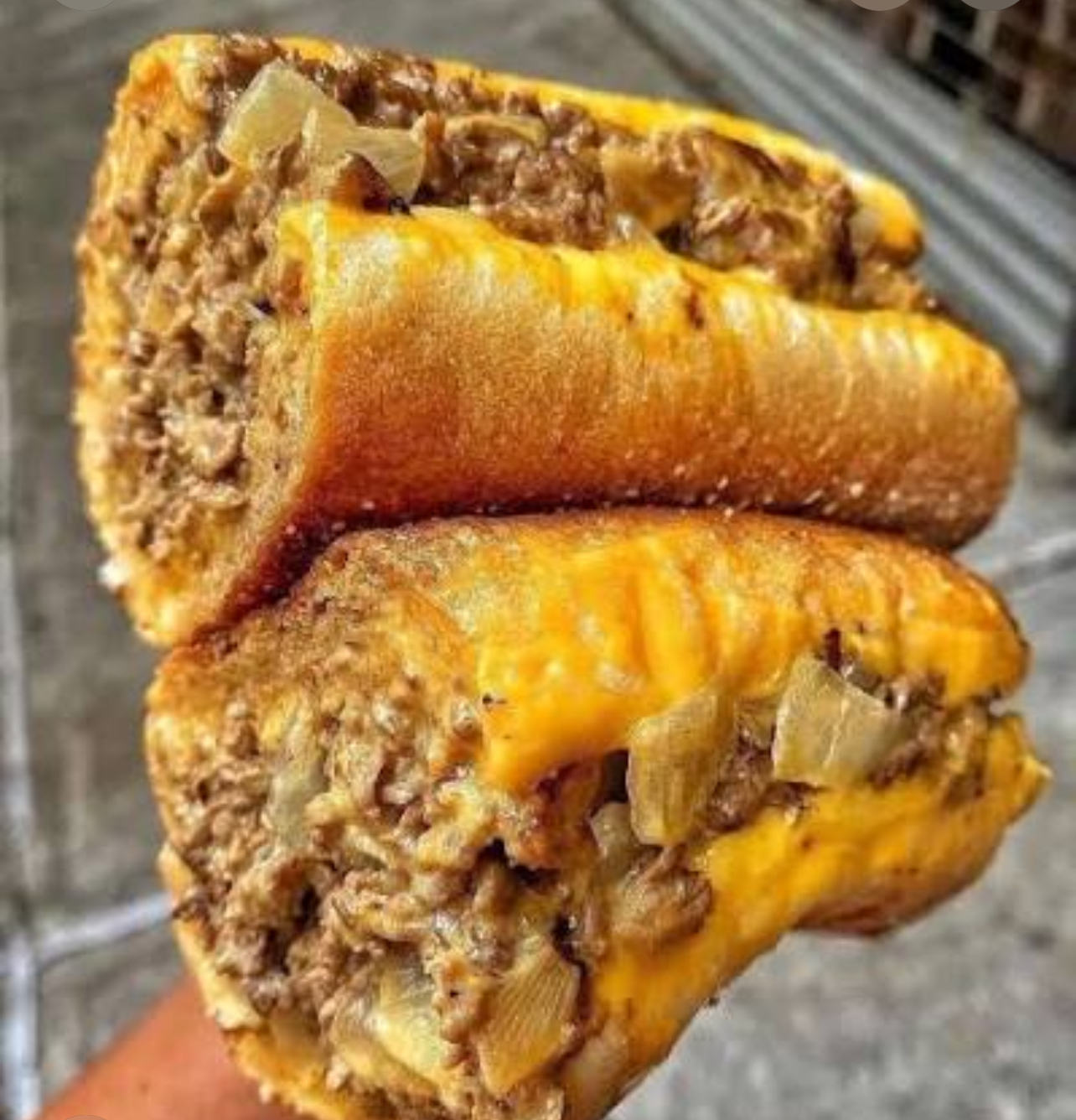 Mallie's Philly cheesesteak halved on a toasted roll with chopped ribeye, melted cheese and grilled onions