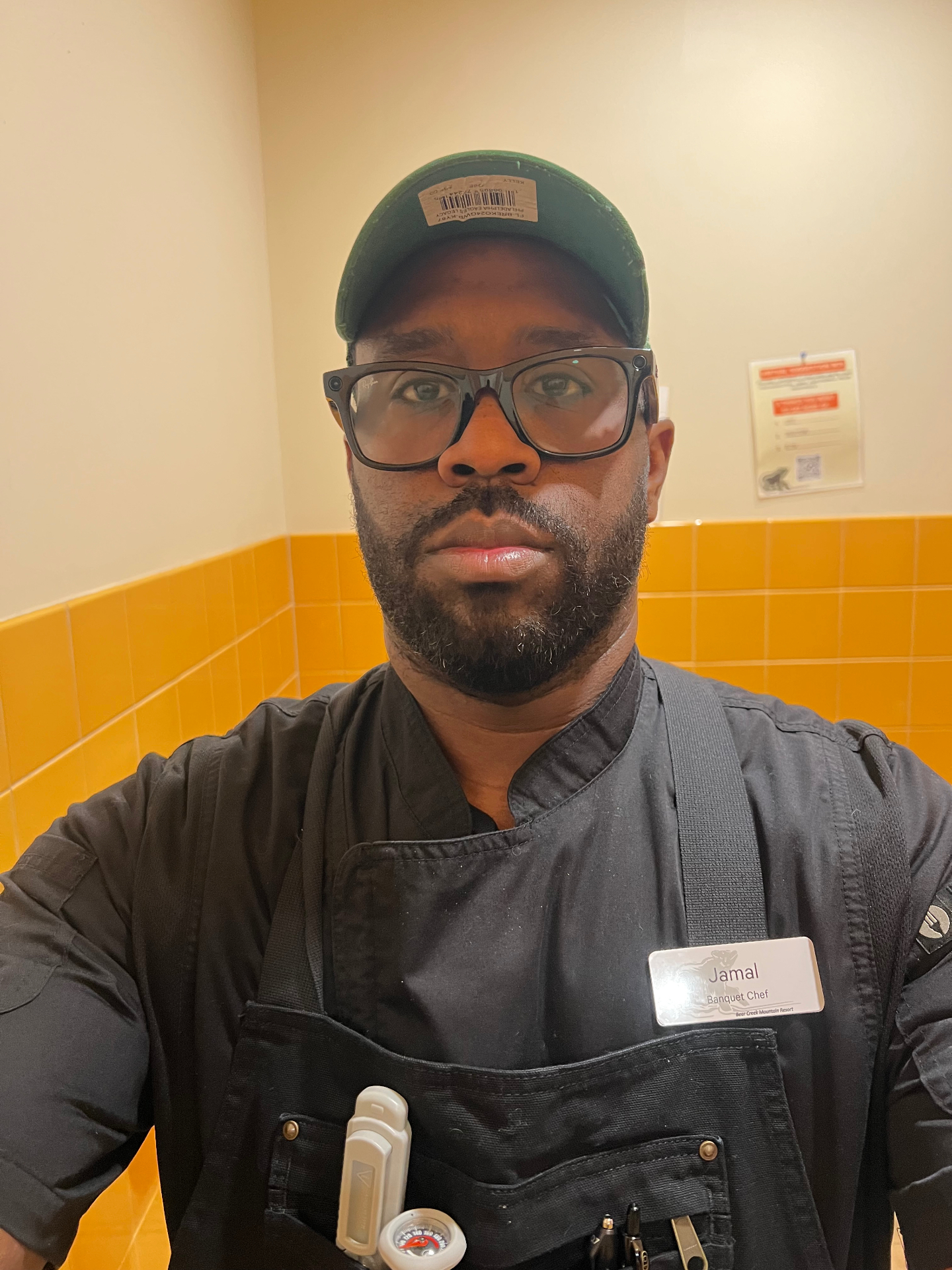 Chef Jamal, founder of Mallie's Burgers, in black chef coat and apron with a banquet chef name tag