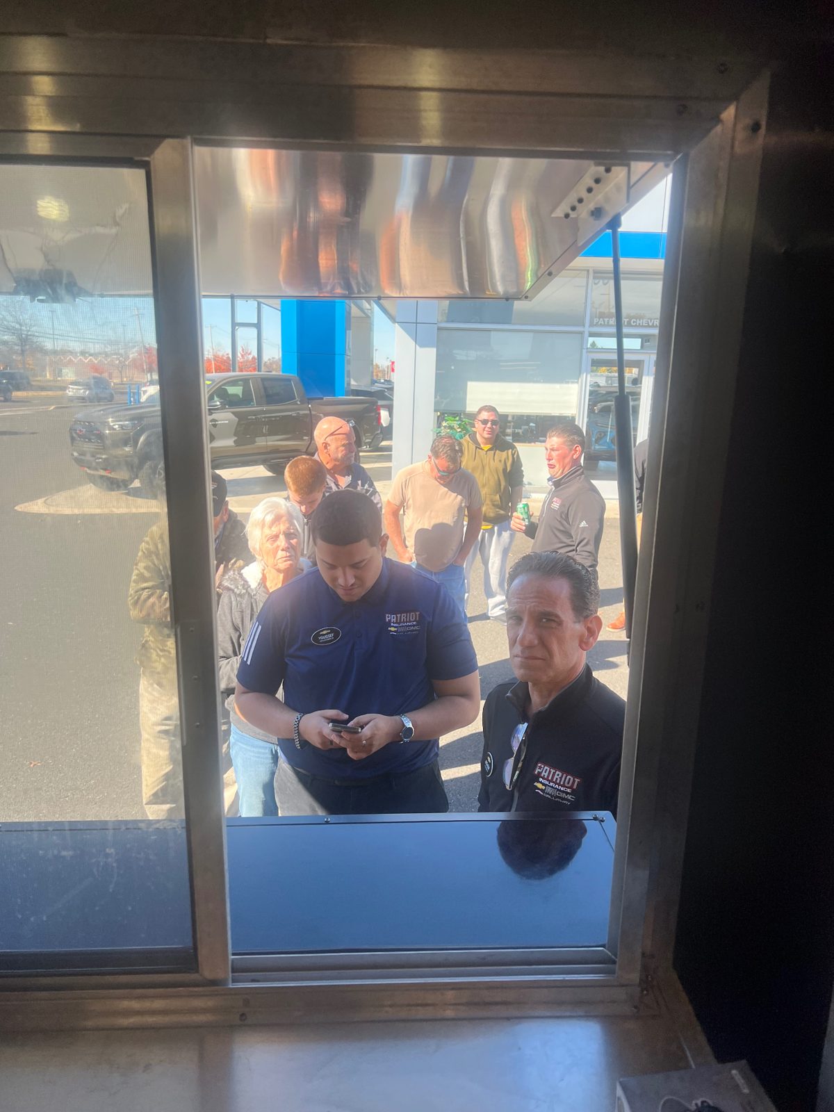 Patriot Chevrolet staff and customers waiting at the Mallie's Burgers service window